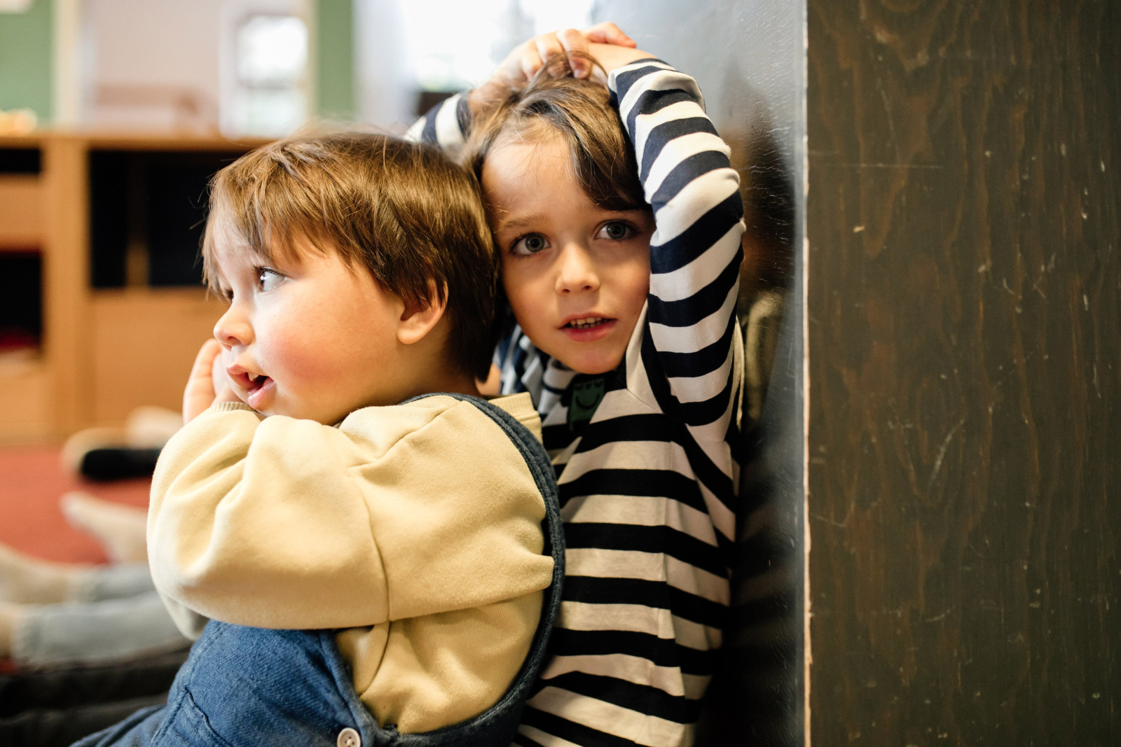 Zwei Kinder kuscheln sich im Gruppenraum aneinander