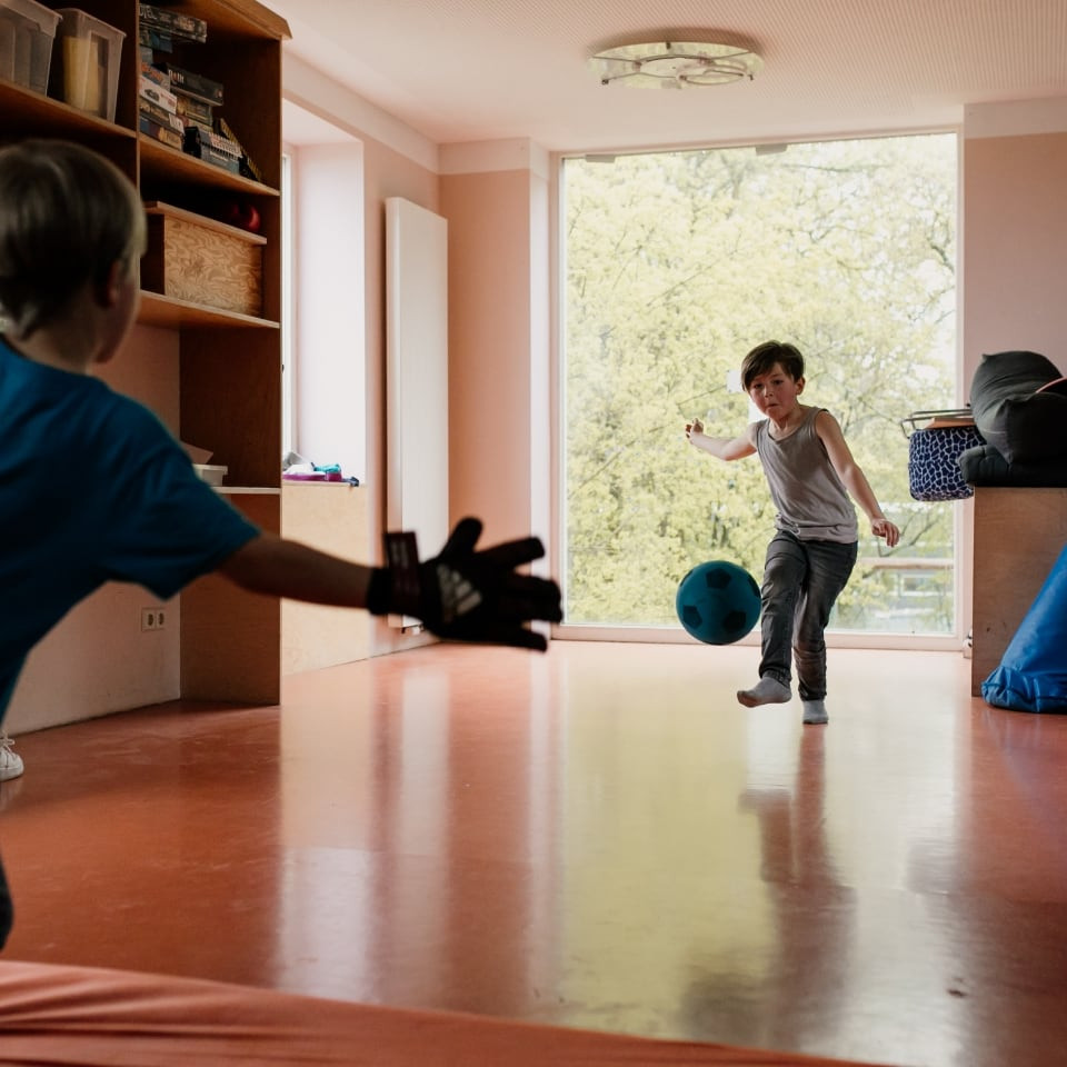 Schulkinder spielen Ball im Toberaum