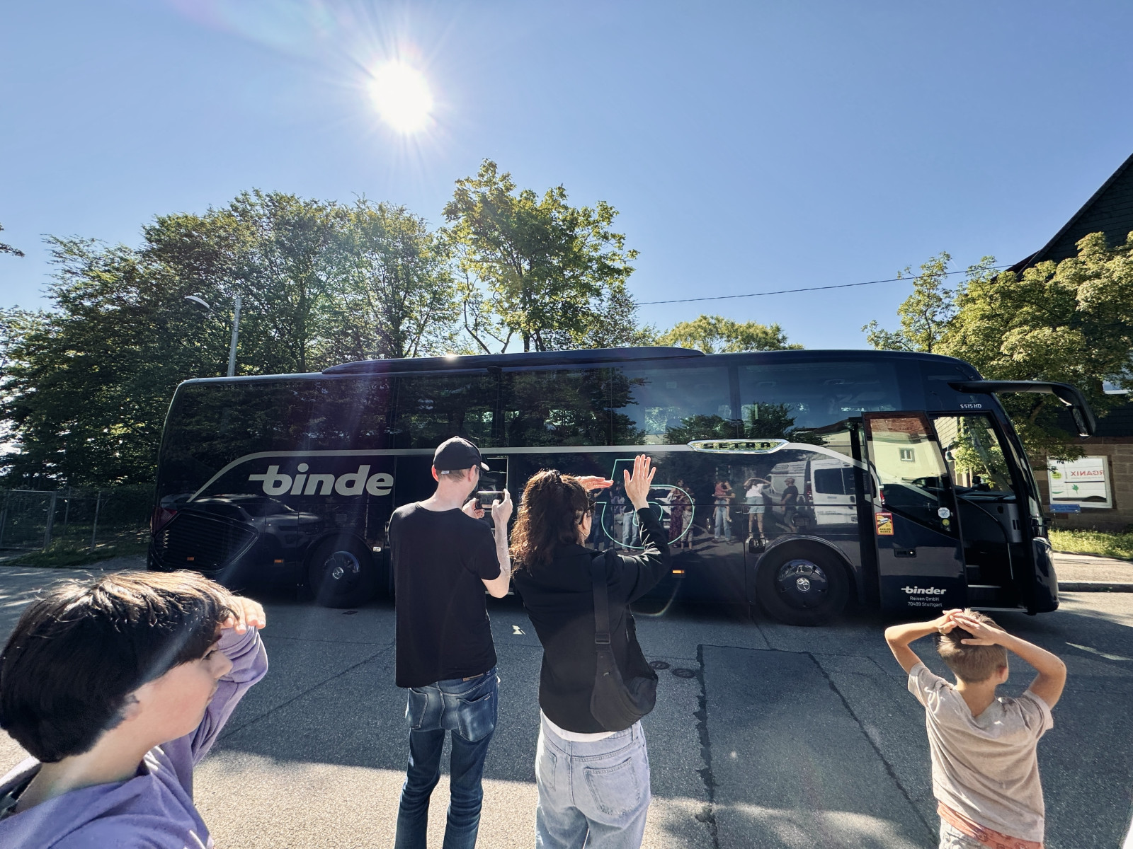 Kinder winken einem Reisebus zum Abschied