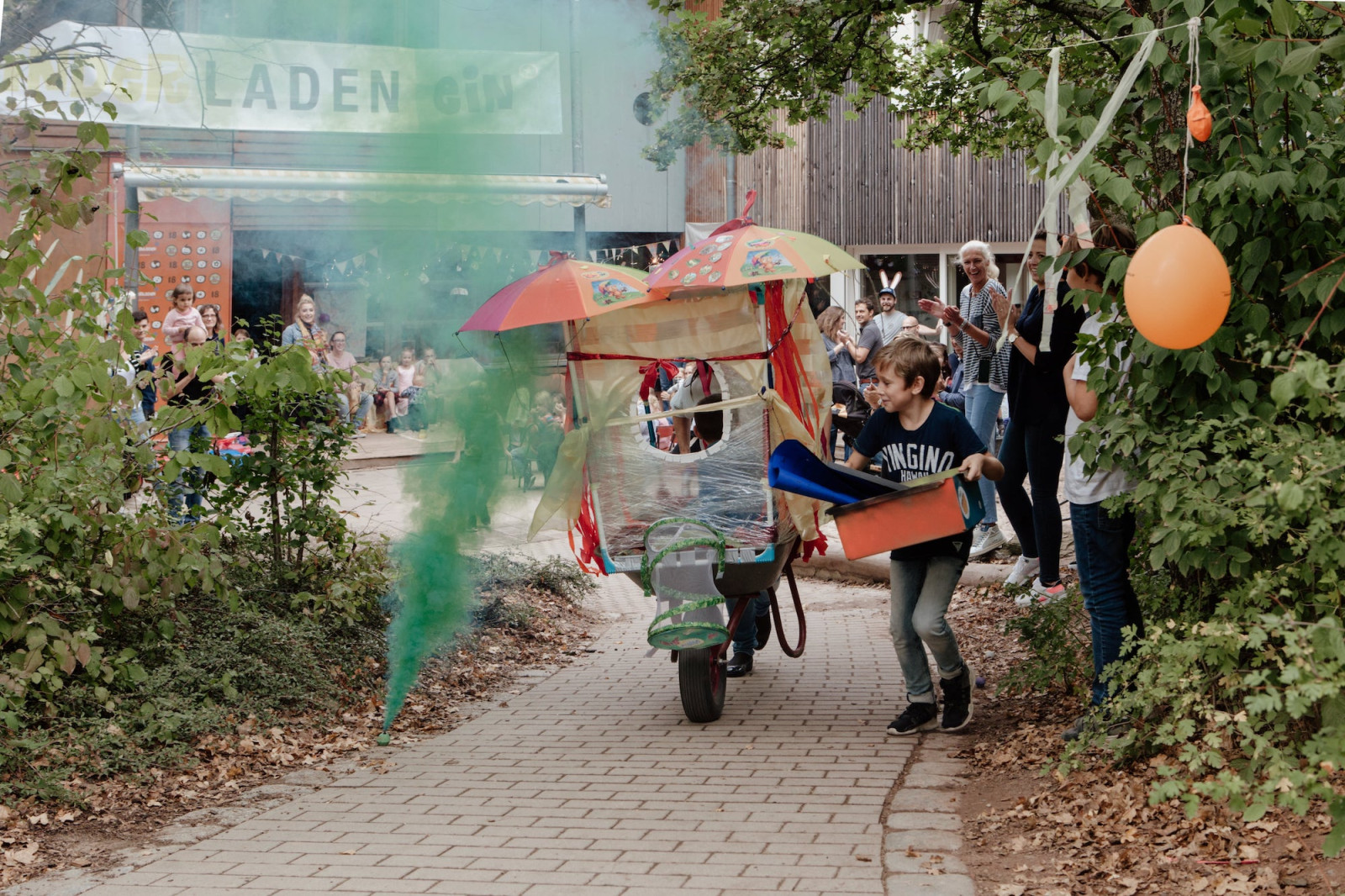 Fest vor dem Kinderladen mit Luftballons und bunten Rauchfackeln