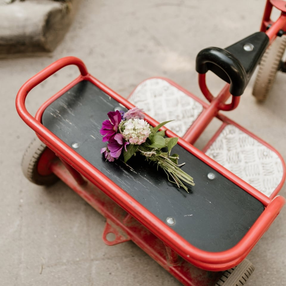 Ein rotes Rutschfahrzeug mit einem Blumenstrauß