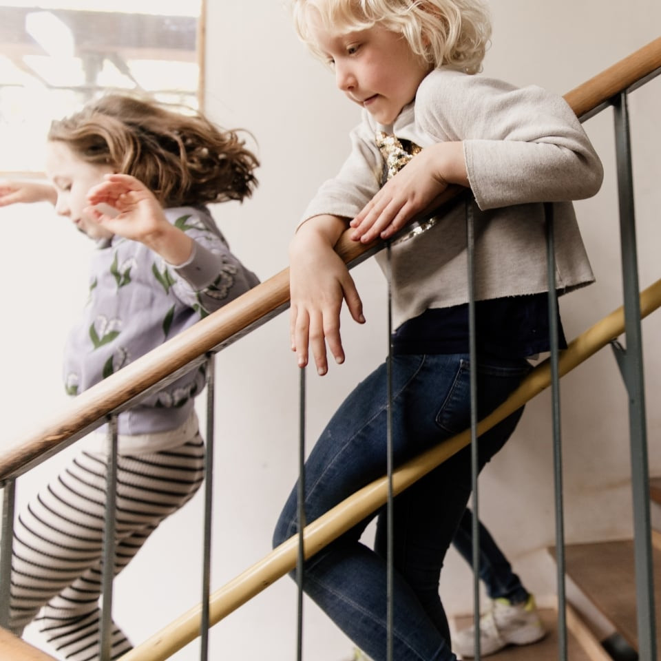 Zwei Kinder laufen die Treppe hinunter